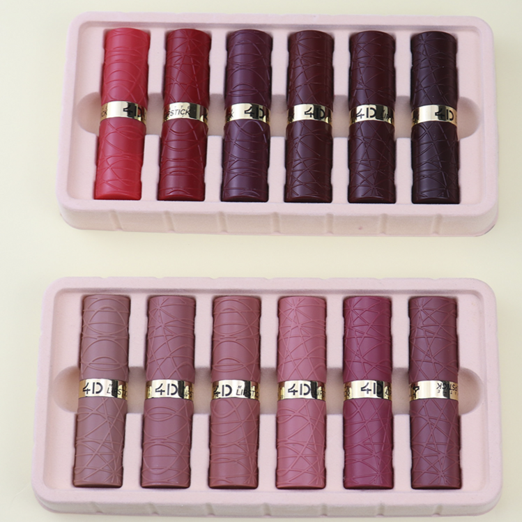 Set of red and burgundy lipsticks in two pink cases on a light beige background.
